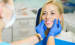 Uśmiechnięta pacjentka z pięknymi zębami, dentysta ocenia estetykę stomatologiczną.
