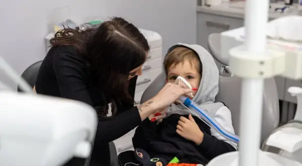 Chłopiec w masce znieczulającej u dentysty. Po zabiegu może pojawić się krwiak po znieczuleniu u dentysty, ale teraz liczy się spokój.