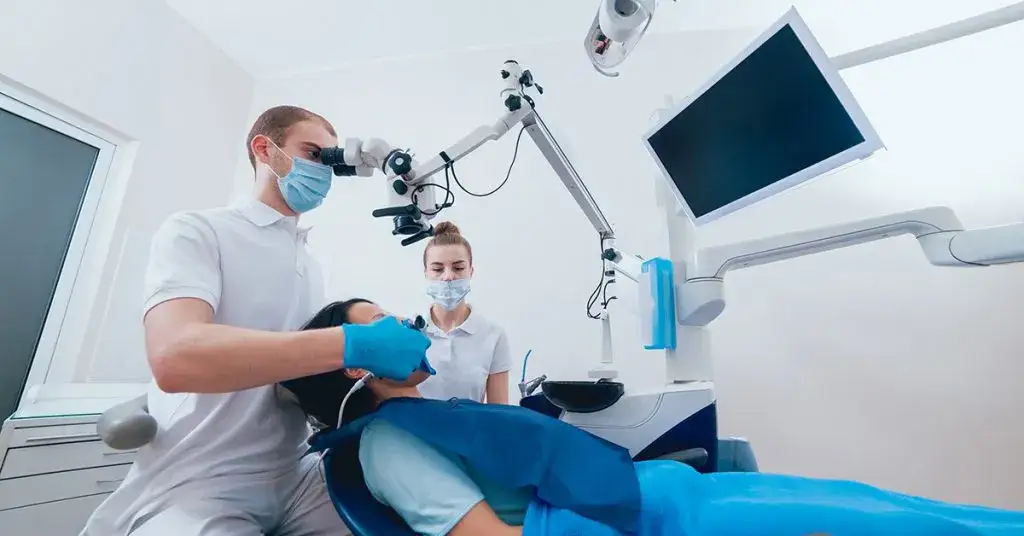 Stomatolog leczący ząb pod mikroskopem