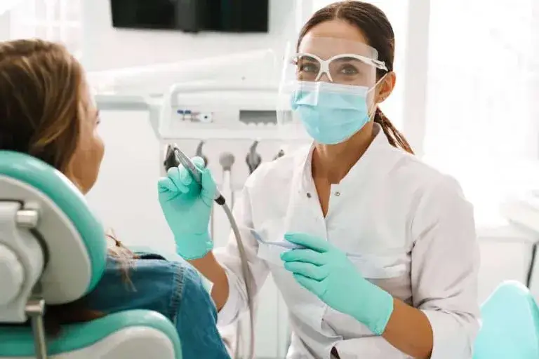 dentysta bada pacjenta, stan zapalny jamy ustnej