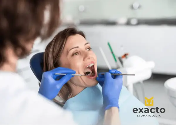 Chirurgiczne usuwanie ósemki w ciąży wymaga precyzji. Dentysta bada jamę ustną pacjentki, przygotowując się do zabiegu.